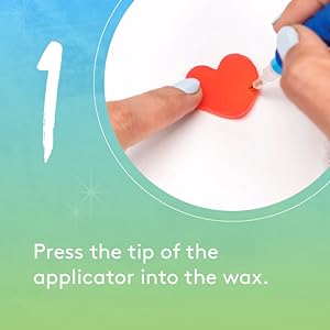 The tip of an applicator being dipped into a heart-shaped wax strip