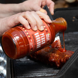 BBQ Sauce poured on steak for grilling