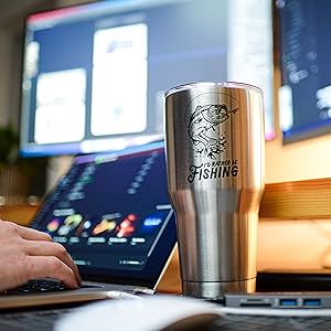 Fishing Stainless Steel Tumbler sitting on a desk with a man working on computer